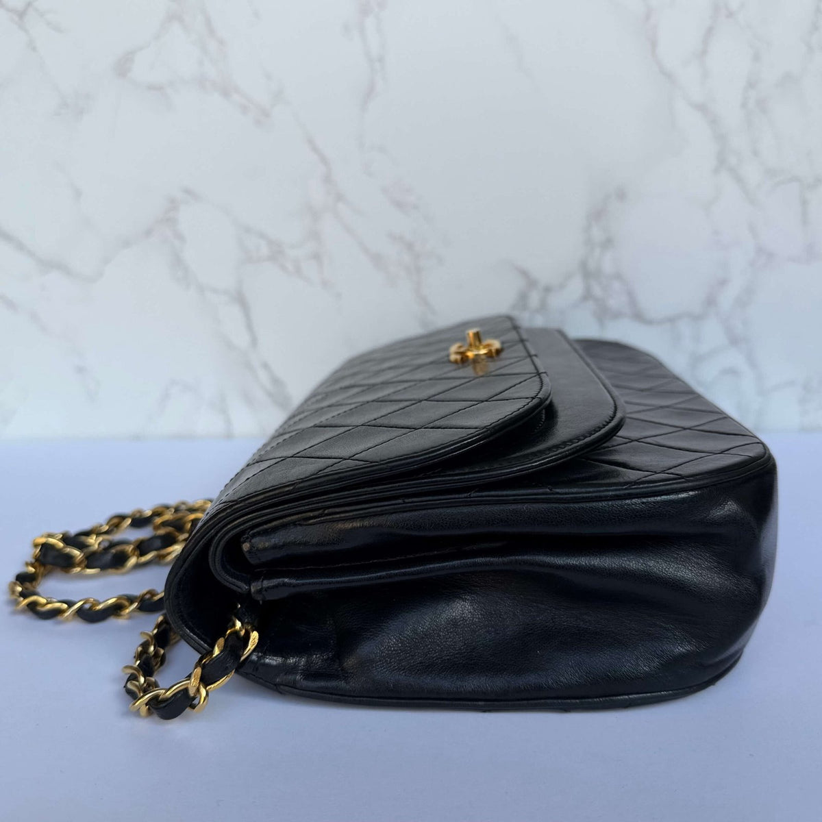 Side view of Chanel half moon flap bag in black