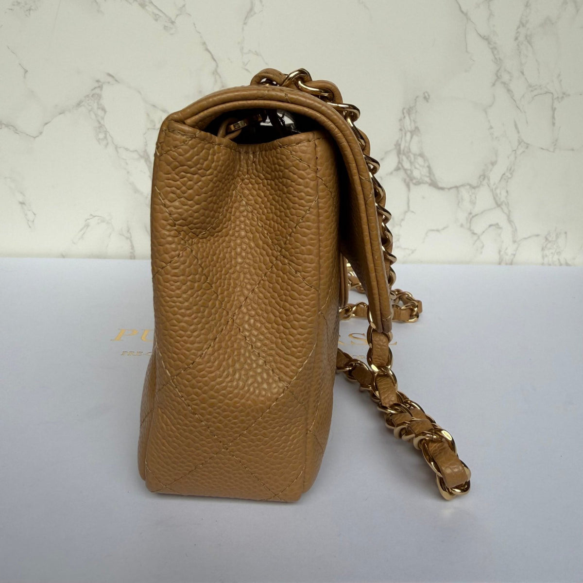 zijkant Chanel East West flap beige caviar