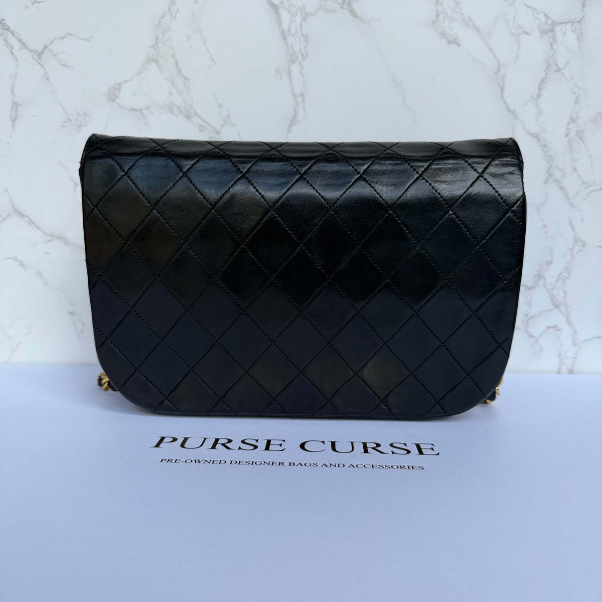 Backside of authentic Chanel half moon double flap bag in black lambskin