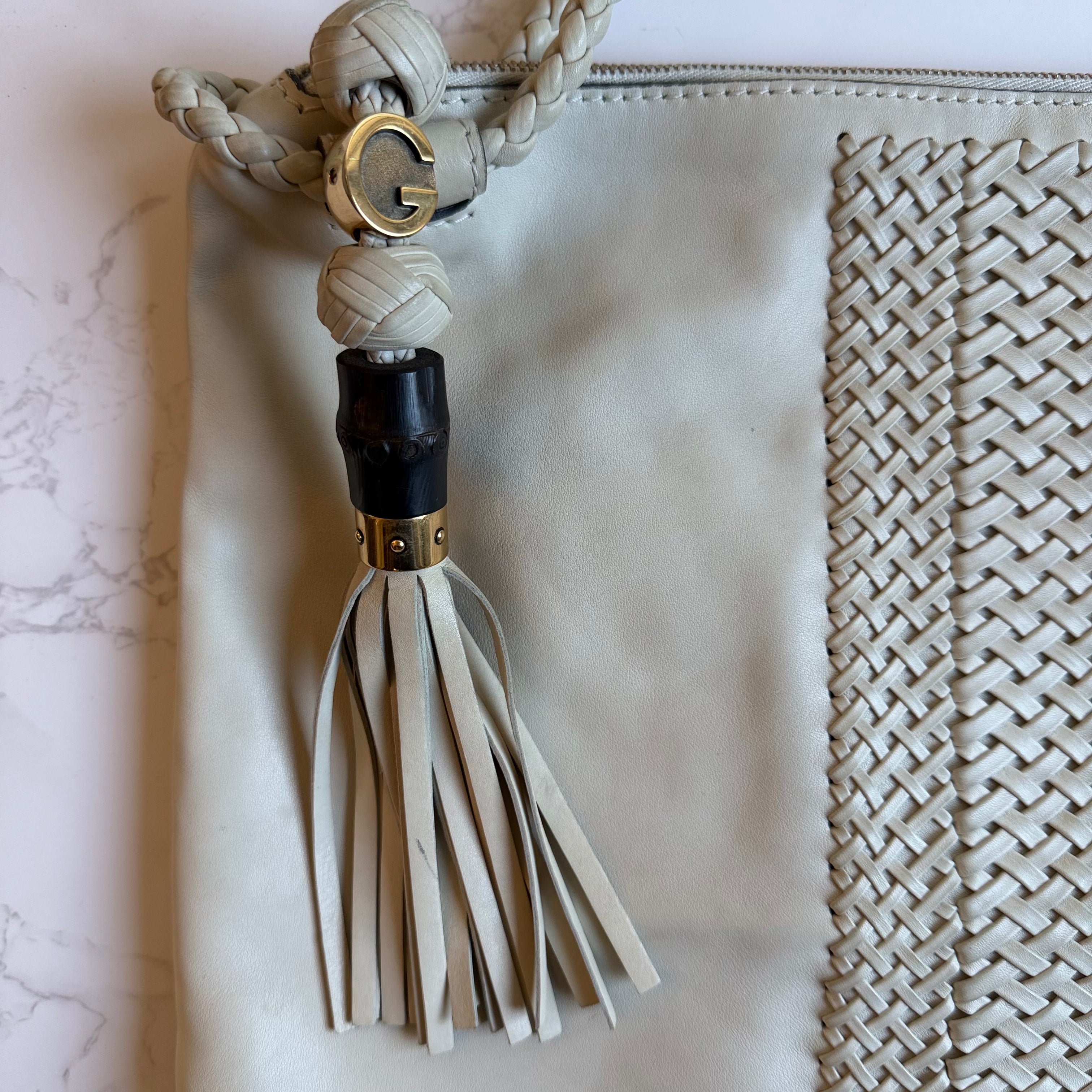 Gucci G bedel en fringe tassel detail