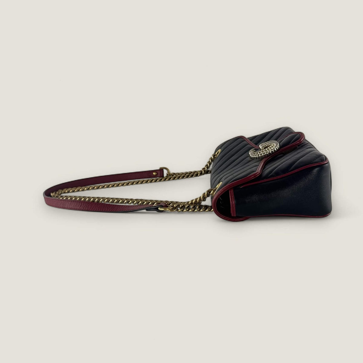 Side view of pre-owned Gucci GG Marmont in black with red leather