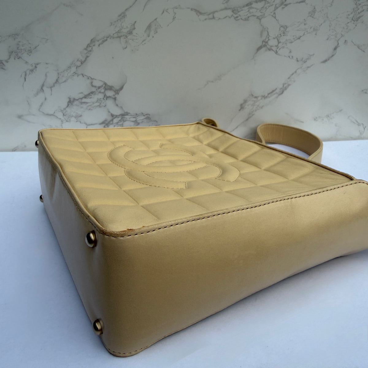 Zijkant Chanel chocolate bar CC logo beige lamsleer
